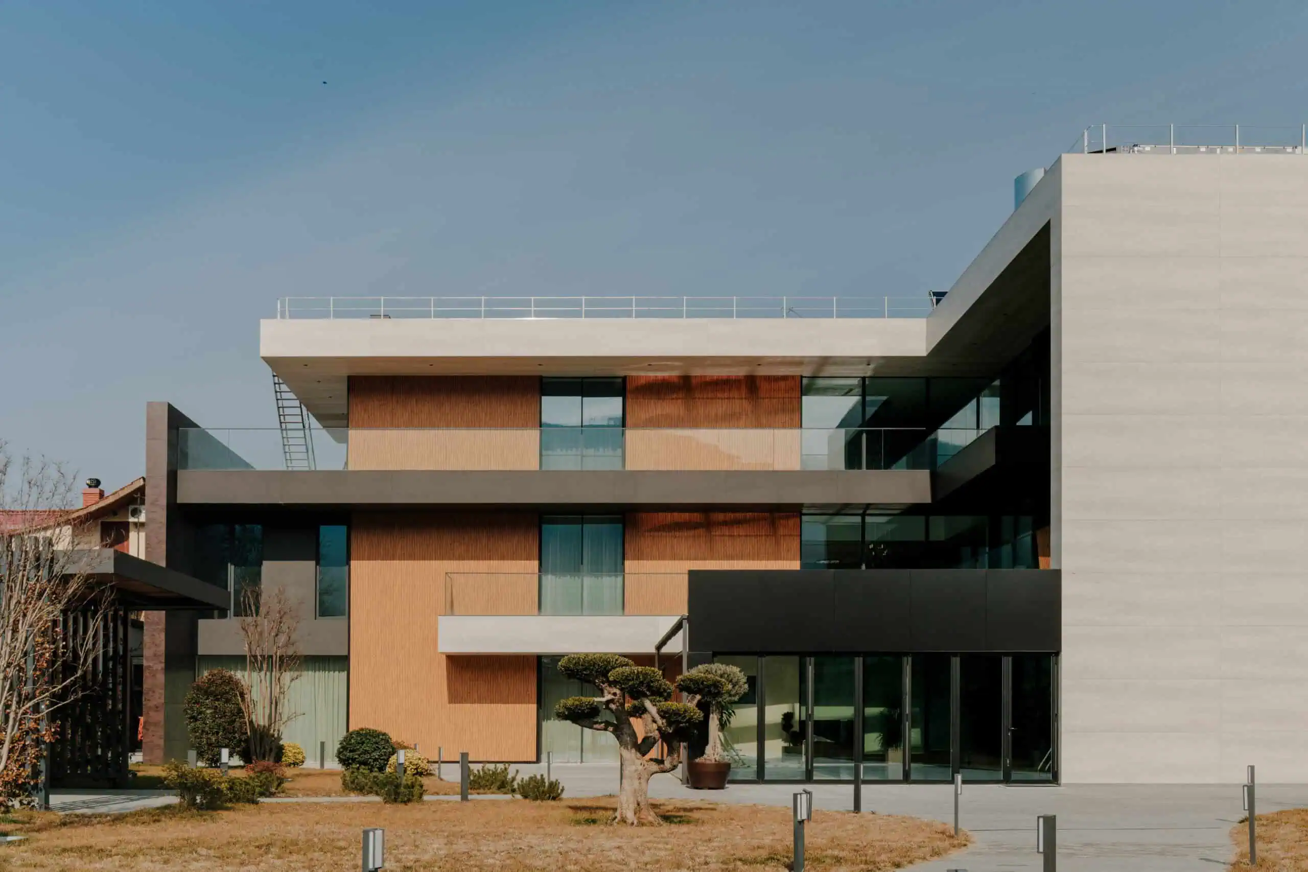 Contemporary modern building with glass balconies and mixed materials, designed by Studio 9.