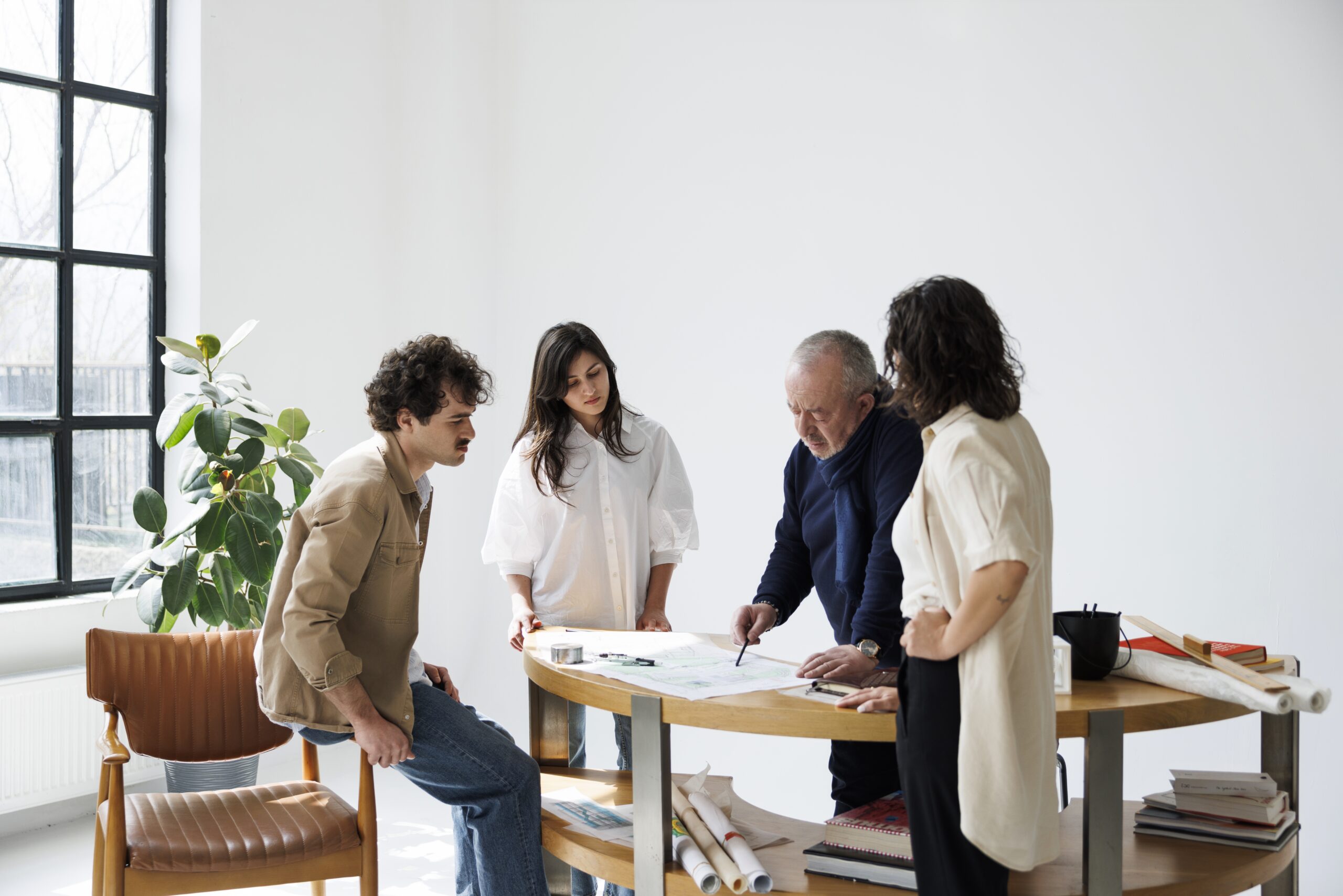 Modern interior design studio workspace with team collaborating on architecture project.