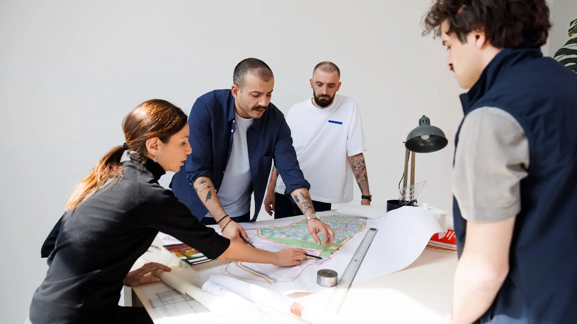 Architects collaborating on city planning blueprint at Studio 9.